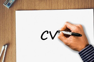hand writing "CV" on a sheet of paper