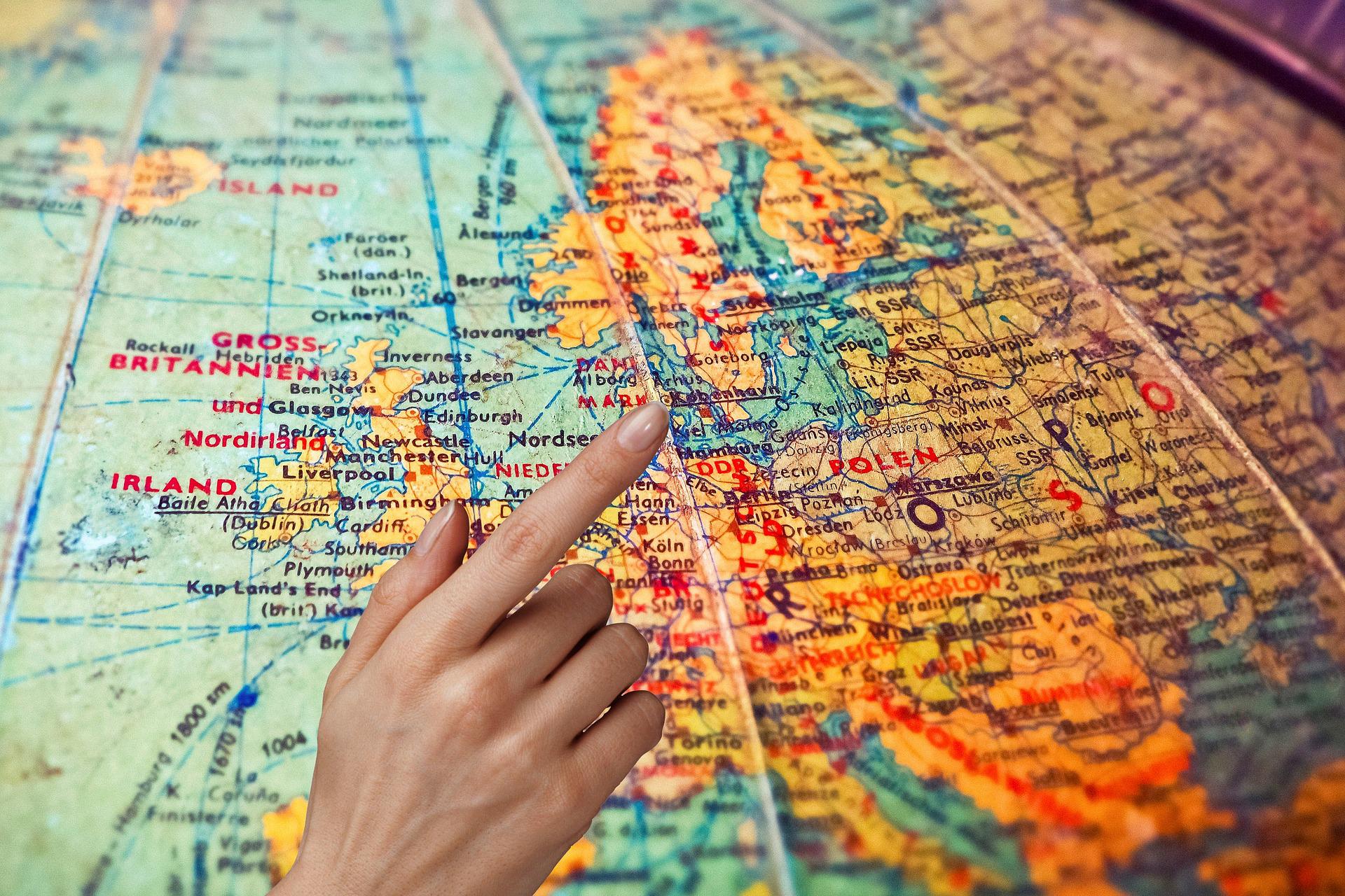 Hand pointing at a global map